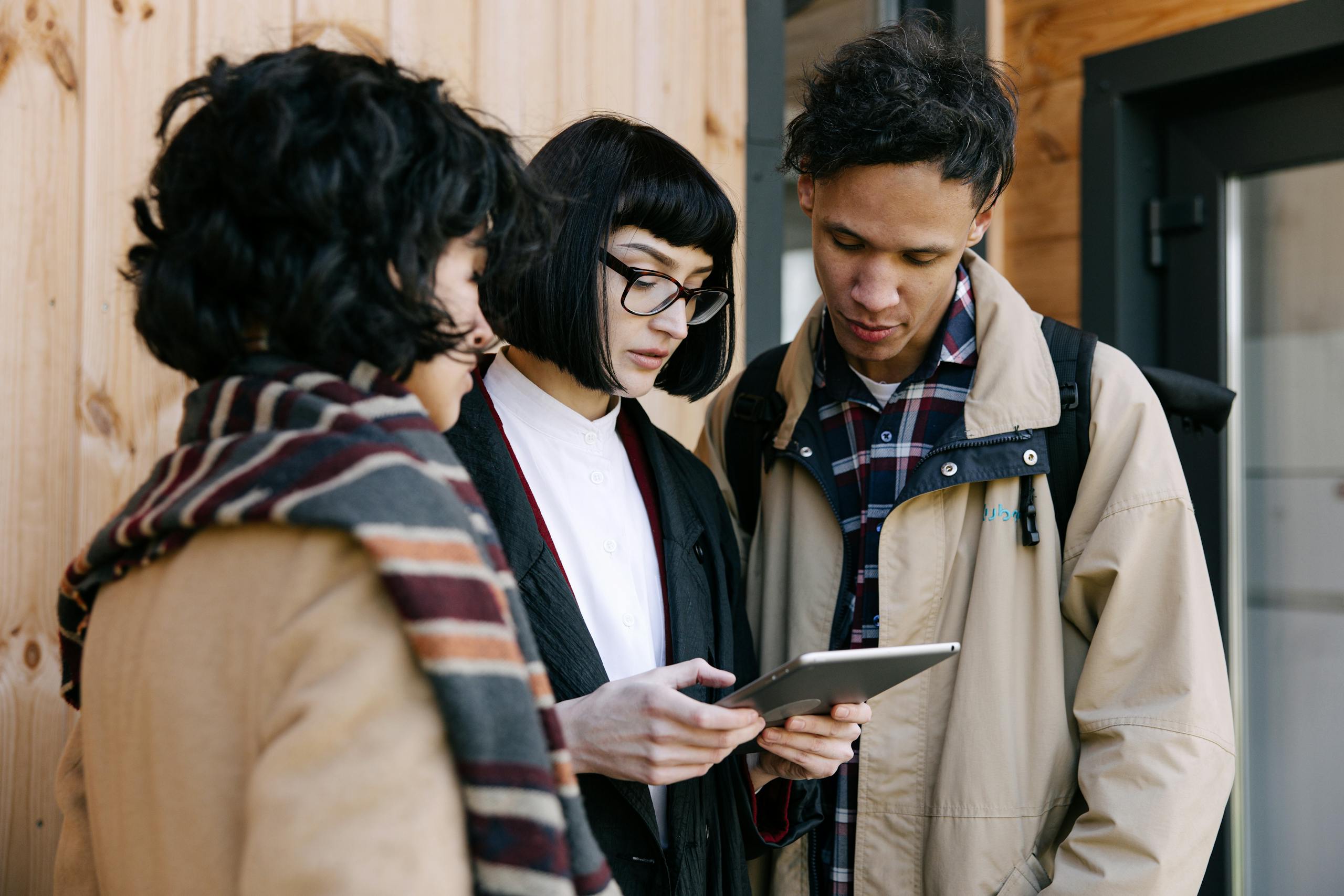 A group of young professionals collaborating over a tablet for real estate planning.
